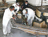 Applying fiberglass to a boat mold.