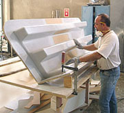 Worker sands fiberglass steps for a Marina Bull forklift.